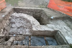 L'immagine mostra il risultato della campagna di scavo sulla città romana. Il saggio nella foto è stato aperto in una porzione angolare di una struttura absidata, che si è rivelata essere con certezza un tempio romano, anche grazie all’eccezionale scoperta dei resti dei piani pavimentali con decorazione di pregio in lastre di marmo.